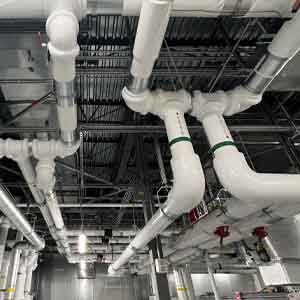 mechanical-insulation-1 Mechanical insulation installed on commercial piping and equipment in a large mechanical room.