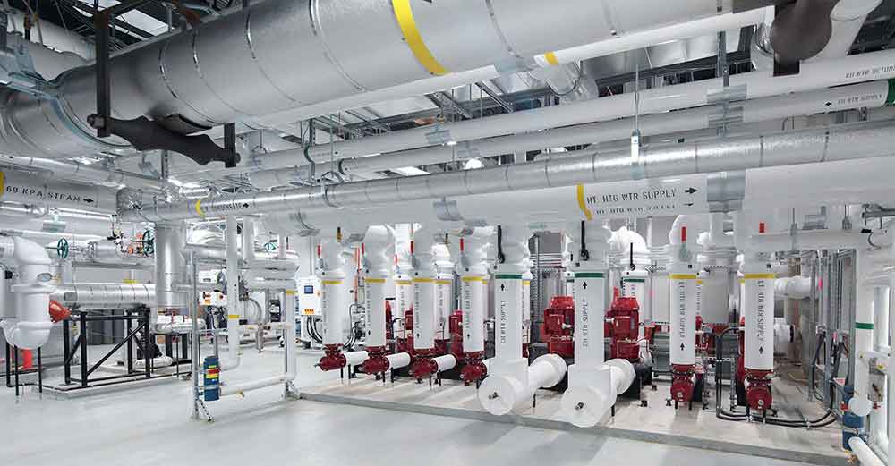 mechanical-insulation-1 Mechanical insulation installed on commercial piping and equipment in a large mechanical room.